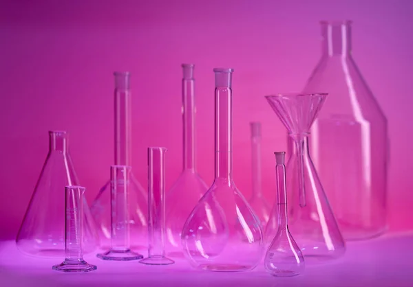 紫罗兰色环境下的各种实验室玻璃器皿 — 图库照片