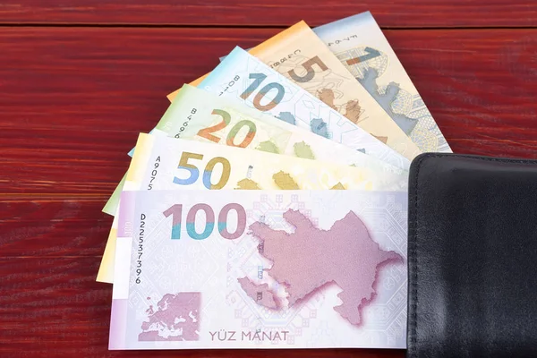 木製の背景に黒い財布の中のアゼルバイジャンマナト — ストック写真