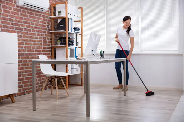 Happy Young Female Janitor Cleaning Floor Broom Office — стоковое фото
