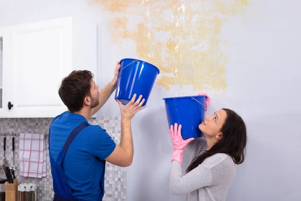 Young Woman Repairman Blue Bucket Collecting Water Damaged Ceiling Kitchen — Stock Photo, Image