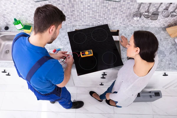 Male Repairman Instalasi Cooker Dengan Wanita Berdiri Dapur — Stok Foto