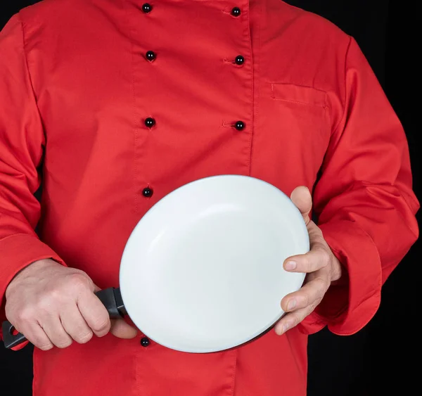 Cozinhe Uniforme Vermelho Segurando Uma Frigideira Branca Redonda Vazia Fundo — Fotografia de Stock