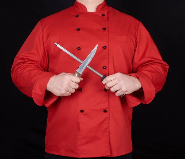 シャープ ナイフ 黒の背景に赤い制服を着たシェフ — ストック写真