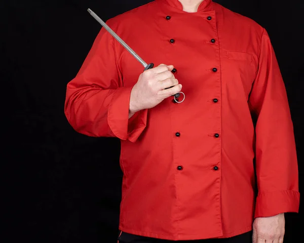 Chef Uniforme Rojo Sostiene Herramienta Afilado Cuchillo Fondo Negro Espacio —  Fotos de Stock