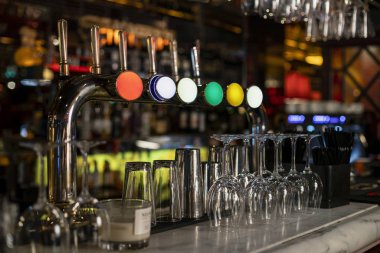 Close-up of a row of beer taps on a bar counter in a restaurant. clipart