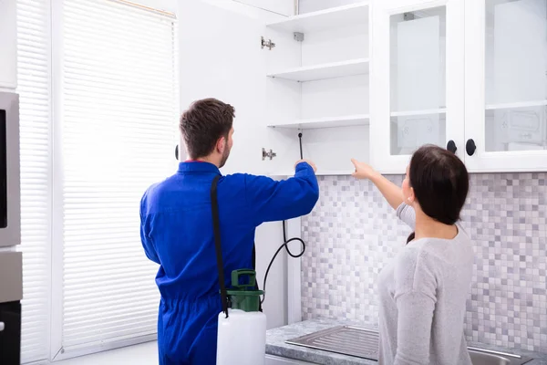 Mulher Mostrando Controle Pragas Trabalhador Pulverizador Inseticida Prateleira Cozinha Doméstica — Fotografia de Stock