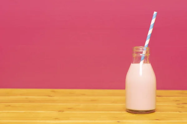 Jordgubbsmjölkshake Med Retro Papperssugrör Pint Glasflaska Ett Träbord Mot Rosa — Stockfoto