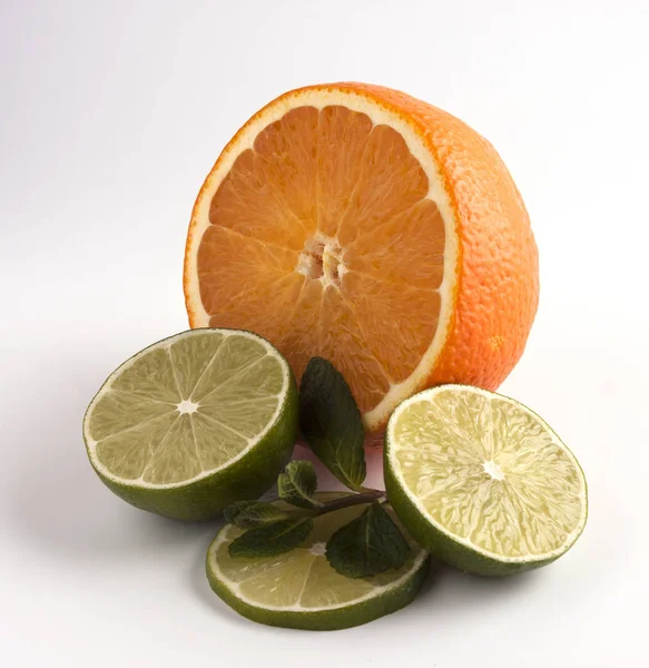 オレンジとライムをミントで半分にスライスした 白地に隔離された柑橘類 — ストック写真