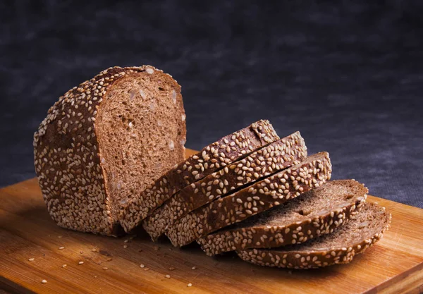 Zwart Meergranen Brood Gesneden Een Bamboe Bord Met Sesam Zonnebloempitten — Stockfoto