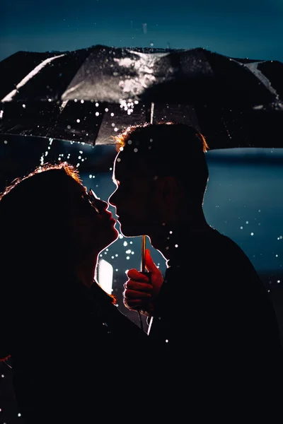 年轻的男人和女人下的伞和雨 — 图库照片