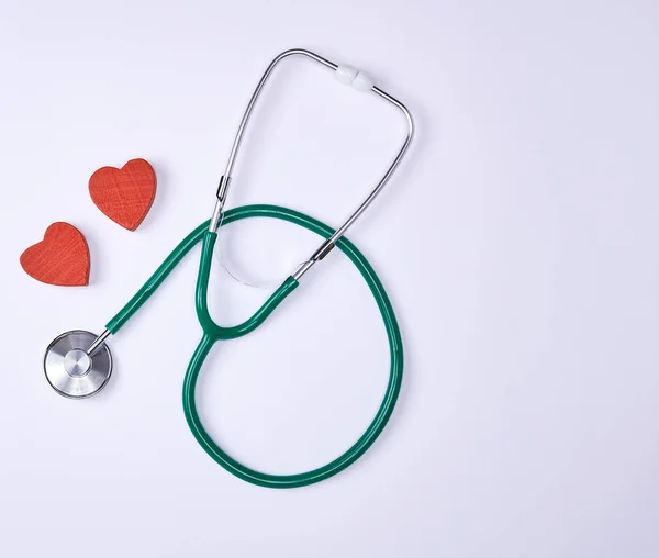 Gröna Medicinsk Stetoskop Och Två Röda Dekorativa Hjärtan Vit Bakgrund — Stockfoto