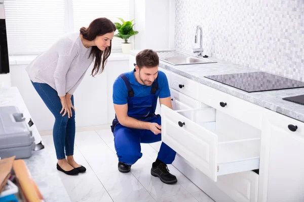 Vrouw Zoek Naar Mannelijke Klusjesman Installeren Deur Van Lade Keuken — Stockfoto