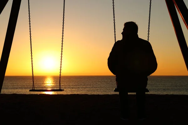 Podświetlenie Sylwetka Człowieka Sam Huśtawce Patrząc Puste Miejsce Zachód Słońca — Zdjęcie stockowe