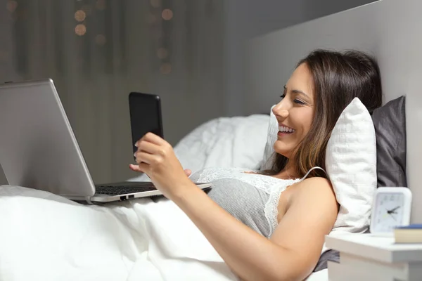 Mutlu Bir Kadın Akıllı Bir Telefon Dizüstü Bilgisayar Kullanıyor Gece — Stok fotoğraf
