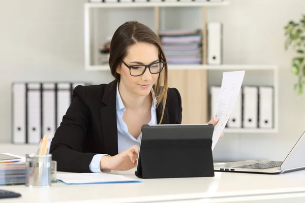 Kontorsarbetare Som Bär Glasögon Jämföra Rapport Med Tablett Innehåll Ett — Stockfoto