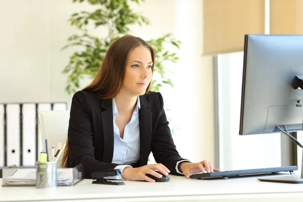 Serious office worker works using a desktop computer