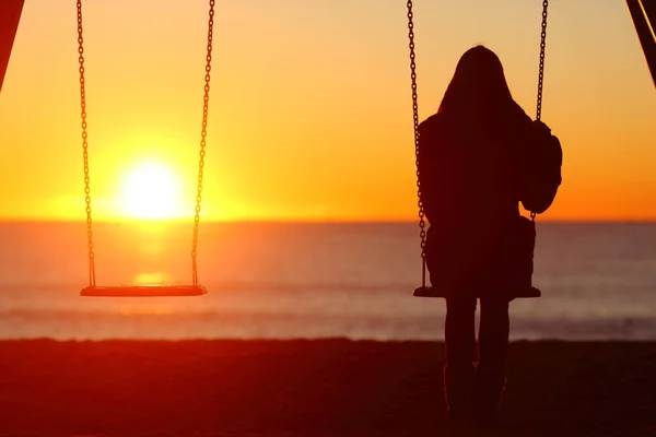 Vista traseira da triste mulher asiática adulta sentada na cama no