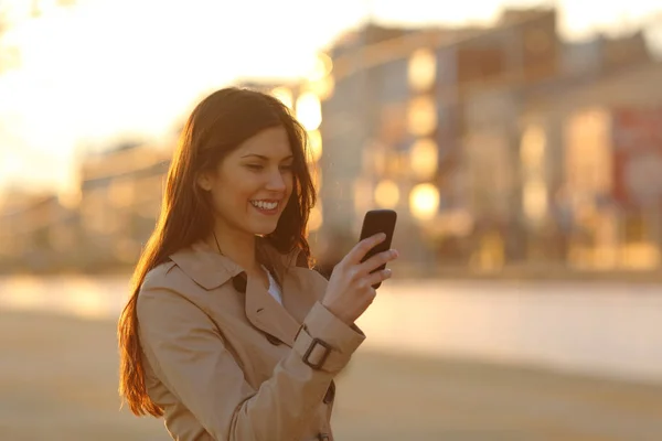 Mujer Feliz Usando Teléfono Inteligente Caminando Atardecer Calle — Foto de Stock