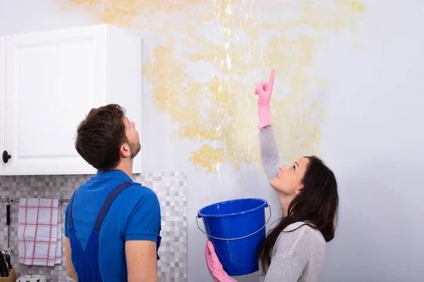 Jonge Vrouw Met Blauwe Emmer Met Water Lekken Uit Schade — Stockfoto