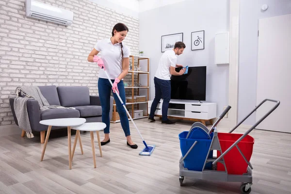 Młodzi Pracownicy Sprzątający Telewizor Podłogę Mopem Gąbką Domu — Zdjęcie stockowe
