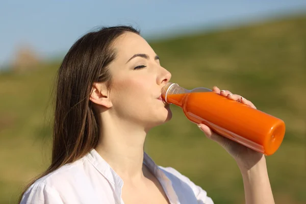 Mujer Bebiendo Jugo Naranja Una Botella Blanco Parque — Foto de Stock