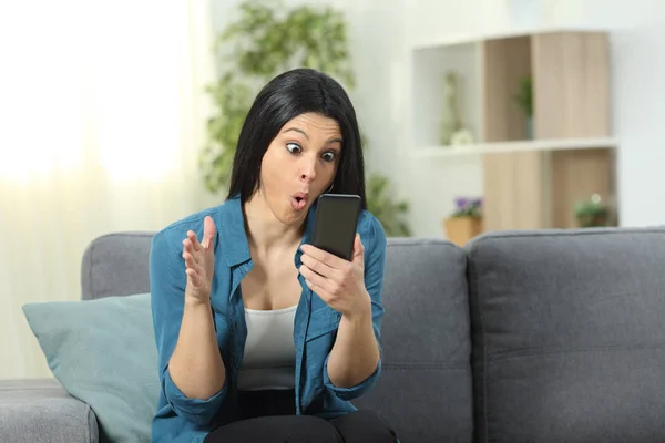 Verblüffte Frau Überprüft Handyinhalt Hause Auf Einer Couch Wohnzimmer — Stockfoto