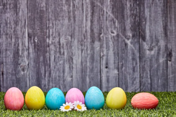 Uova Pasqua Colorate Adagiate Erba Verde Uno Sfondo Legno Grigio — Foto Stock