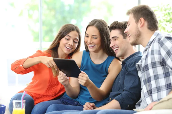 Groep Van Vier Gelukkige Vrienden Controleren Tablet Inhoud Zitten Een Stockafbeelding