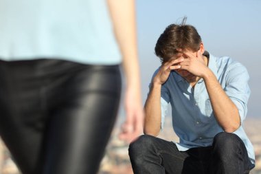 Sad man complaining outdoors after break up. Girlfriend leaving him clipart