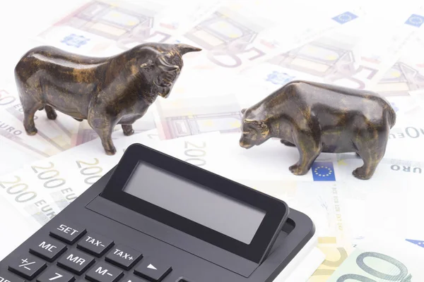 The image shows bull, bear and a calculator on a banknotes