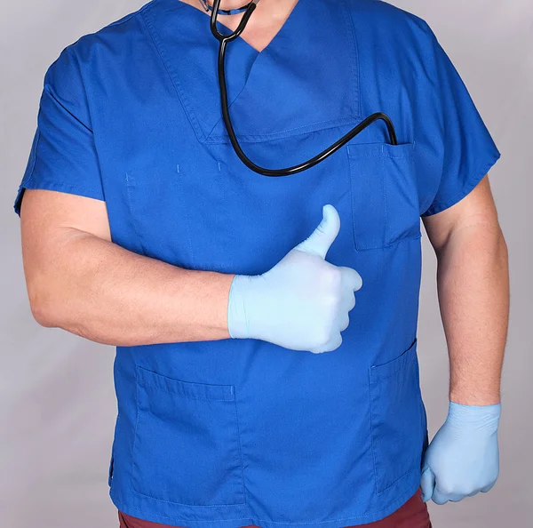 身穿蓝色制服的医生表现出一种赞许的姿态 灰色背景 — 图库照片