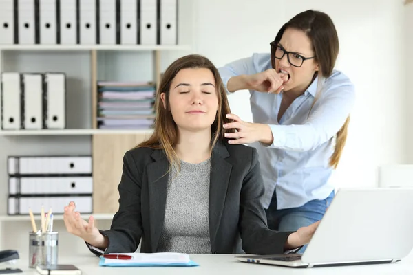 Furious office worker trying to kill her lazy colleague who is wasting time practicing yoga exercises