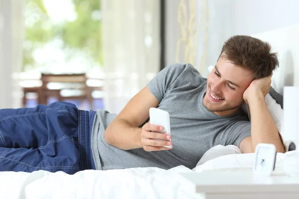 Glücklicher Mann Der Hause Auf Dem Bett Liegend Smartphone Inhalte — Stockfoto