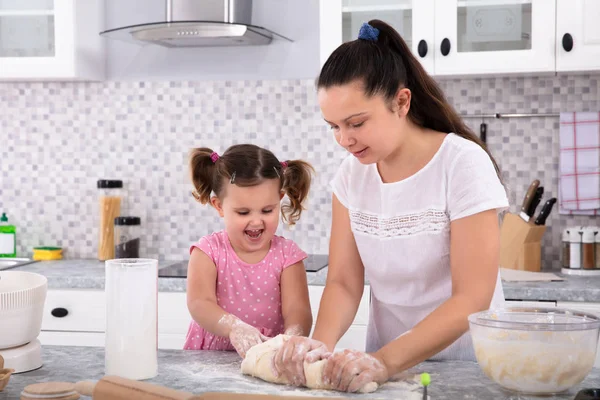 Happy Daughter Helping Her Mother Kneading Dough Kitchen Counter — стоковое фото