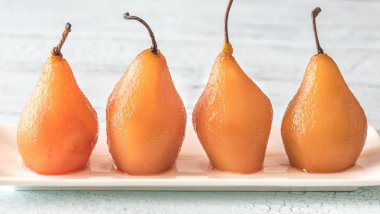 Poached pears in rose wine on the plate clipart