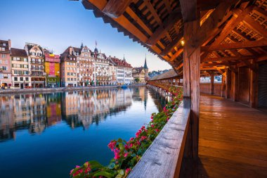 Kapellbrucke historic wooden bridge in Luzern and waterfront landmarks dawn view, town in central Switzerland clipart