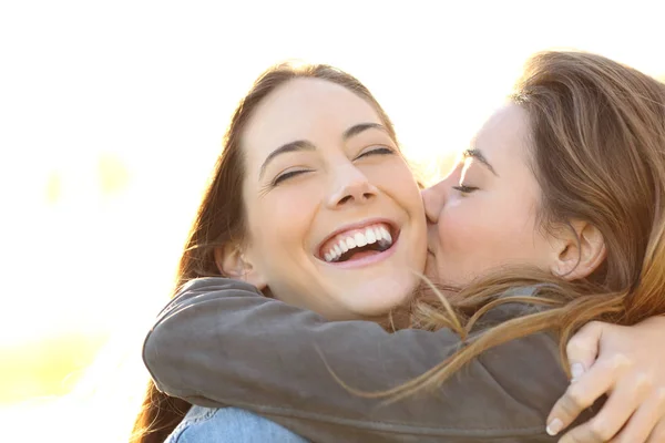 Affectionate Woman Kissing Her Happy Friend Perfect Smile Outdoors — Stock Photo, Image