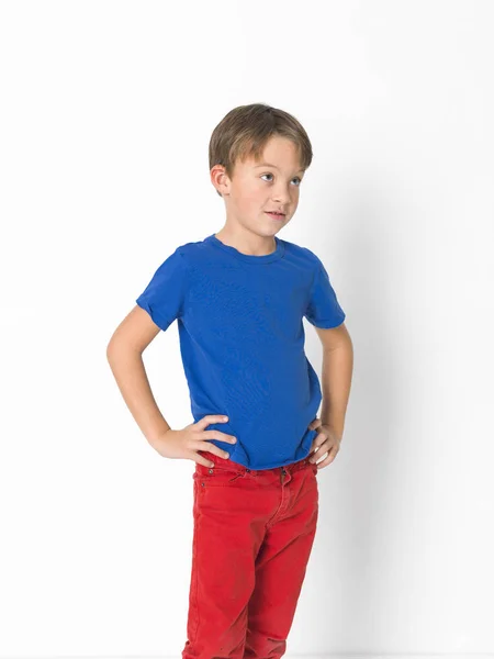 Шестирічний Хлопчик Червоних Штанях Синій Сорочці Позує Перед Білим Тлом — стокове фото