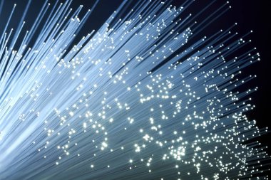A bundle of optical fibers creates points of light in the dark. clipart
