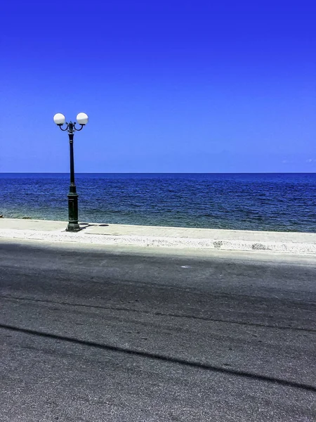 Road with lamp on the cost - Gouves, Crete, Greece