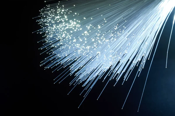 A bundle of optical fibers creates points of light in the dark.