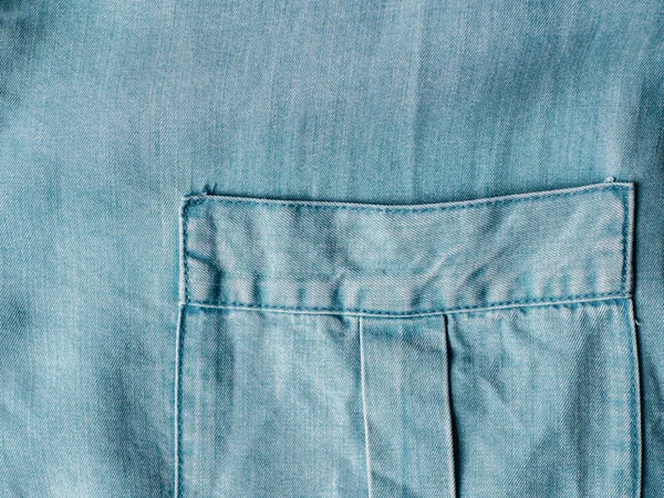 现代柔软的牛仔裤衬衫与乳房口袋纹理关闭 Lyocell Tencel 现代天然纤维素织物蓝色粗斜纹棉布颜色 可用于设计或文本 复制空间 — 图库照片