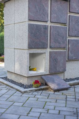 A stone columbarium with an empty niche and without an urn clipart
