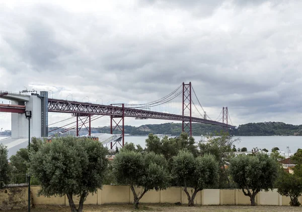 4月25日的悬索桥 画在国际橙色 并于1966年8月落成 穿越塔古斯河在里斯本 葡萄牙 — 图库照片