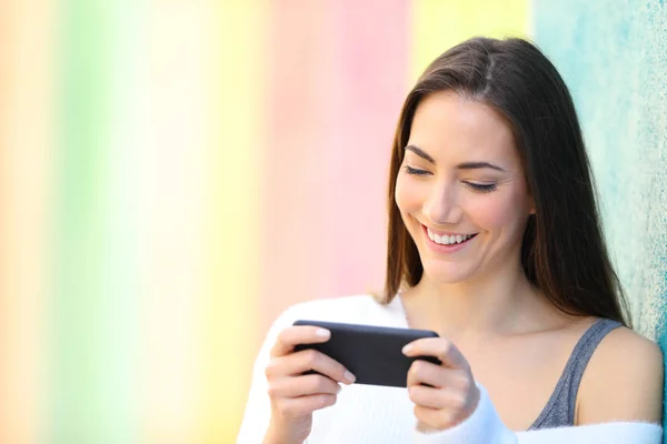 Mujer Feliz Viendo Videos Teléfono Inteligente Apoyado Una Pared Colorida — Foto de Stock