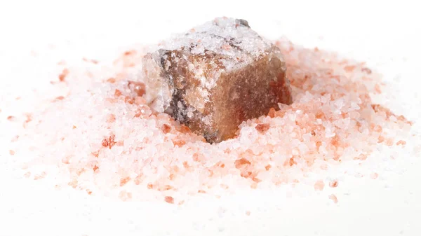白い背景の上の粒ピンク ヒマラヤ塩の杭で大まかな岩塩ミネラル — ストック写真