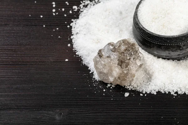 top view of vintage silver salt cellar , rough natural Halite mineral and grained Rock Salt close up on dark brown wooden board