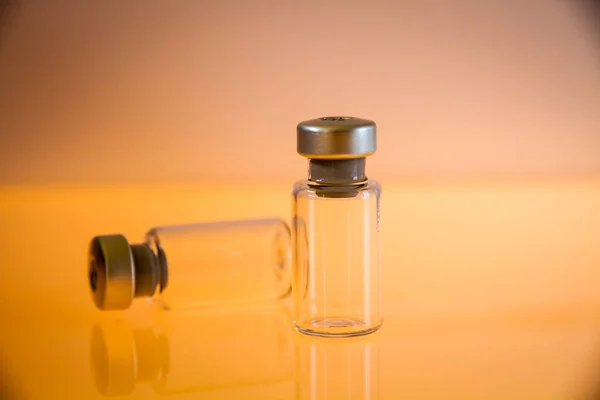 Zwei Impfglasflaschen Auf Orangefarbenem Hintergrund — Stockfoto