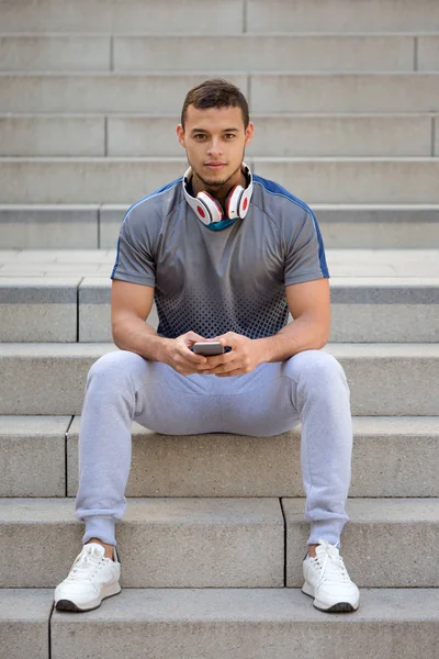Listening to music young latin man with headphones listen portrait format copyspace copy space outdoor