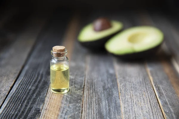 Botella Pequeña Aceite Aguacate Aguacates Sobre Mesa Madera —  Fotos de Stock